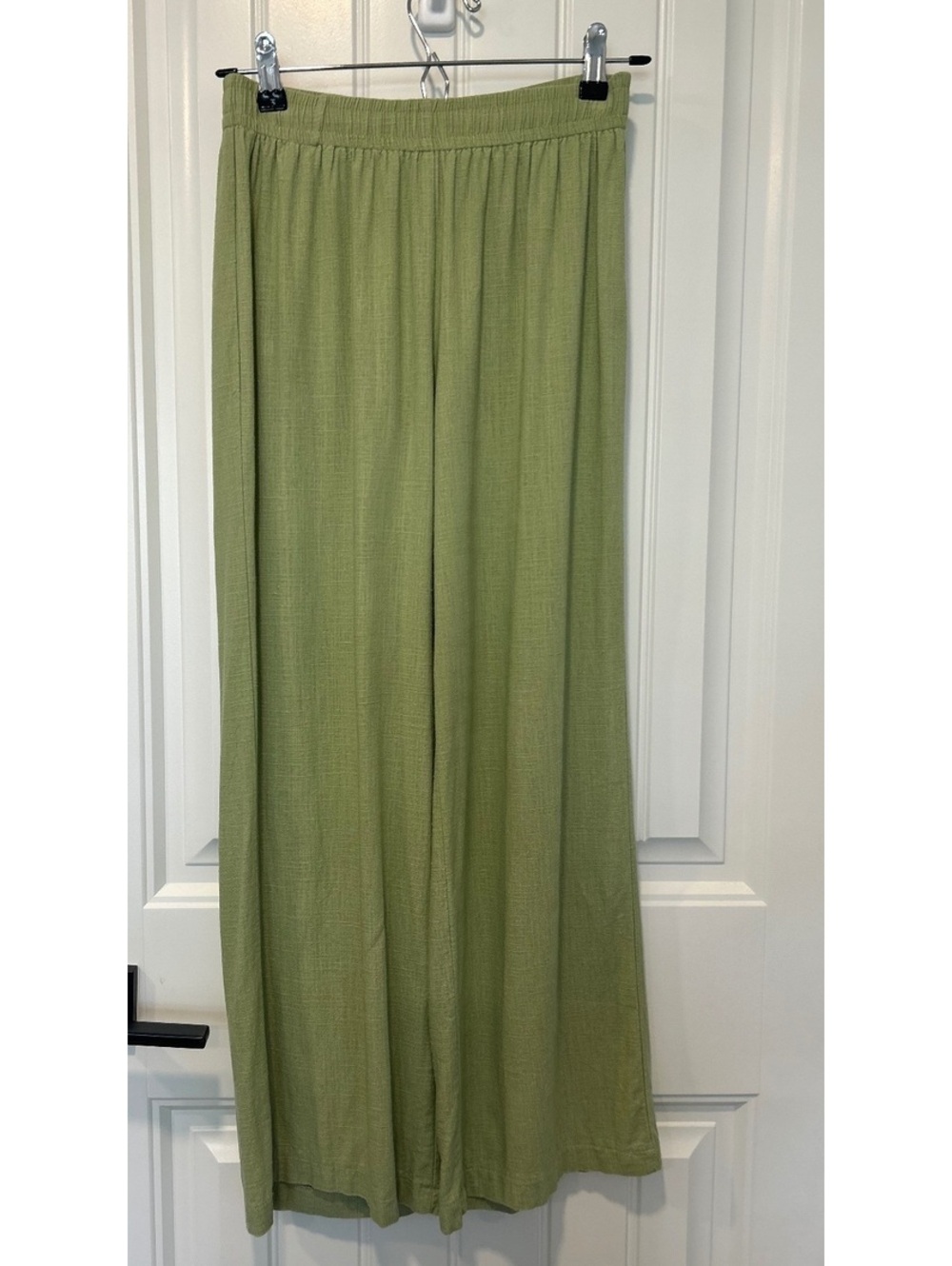 Princess Polly flowy linen blend pants in a soft green.